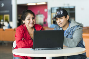 Two students working on a laptop