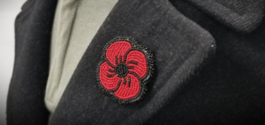 Beaded handmade poppy pin on a lapel of a coat