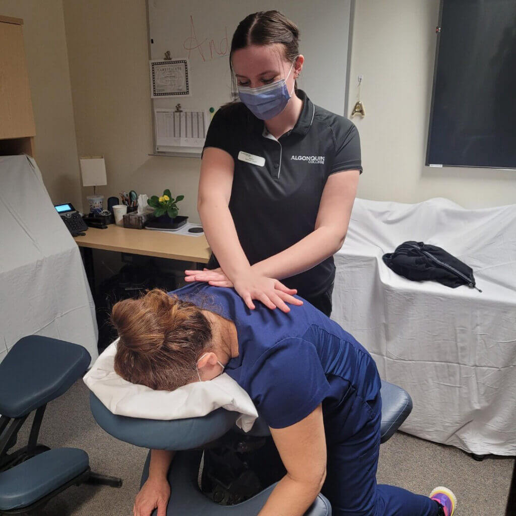 A student gives a back massage to a CHEO employee