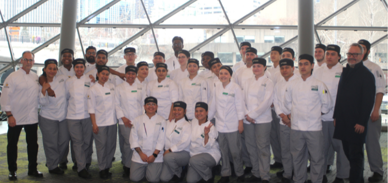 50 Culinary Arts students gather to take a photo with Chris John, lead judge at the Canadian Culinary Championships 2024, and Scott Foeller, Culinary Arts Instructor, at the Shaw Centre in Ottawa, ON.