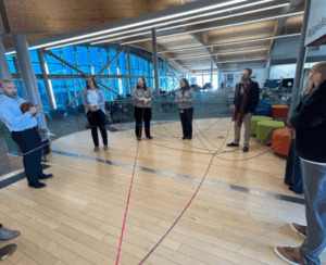 Group of employees taking part in "we are all connected" yarn exercise.