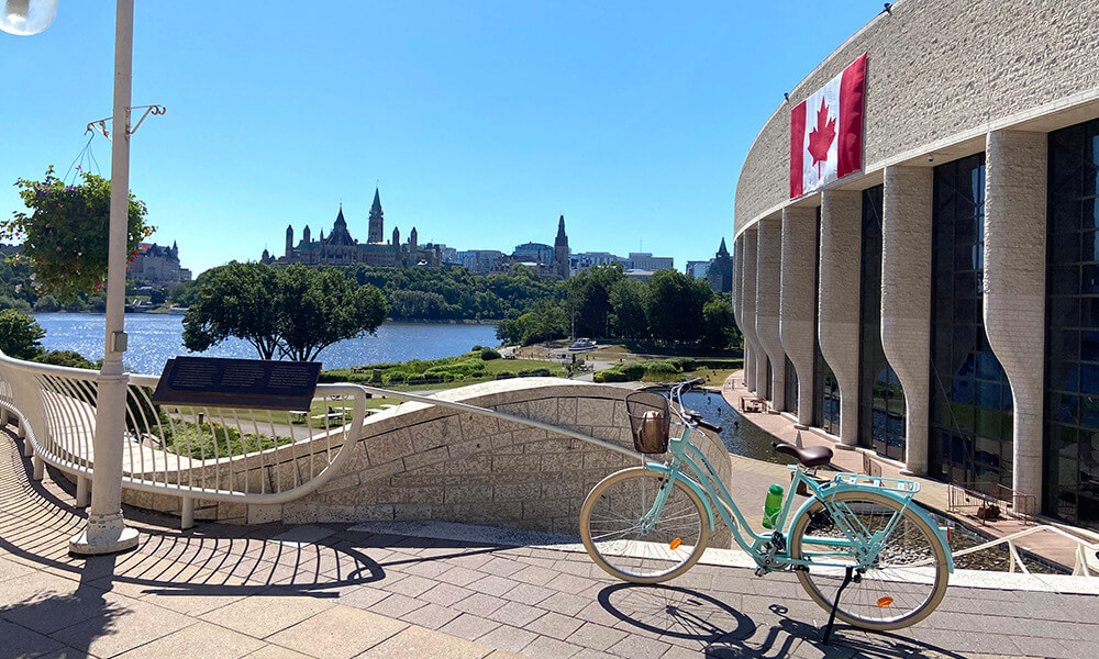 Photo of a bicycle sitting in front of the Museum of History - with Parliament Hill in the background.