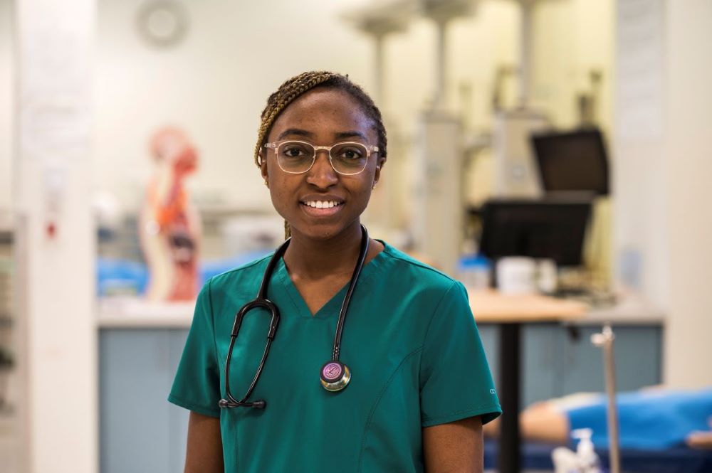 Nursing student in scrubs with stethoscope in the lab