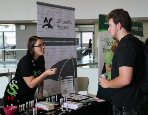 Umbrella Project representative speaking to a student at a College event