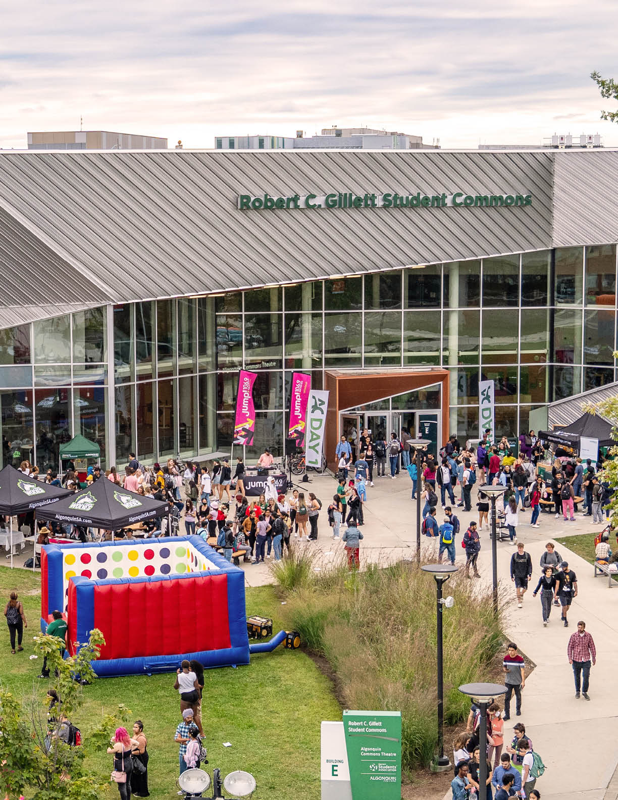 Photo of the Student Commons front lawn during AC Day 1 activities showing many students having fun doing various activities. 