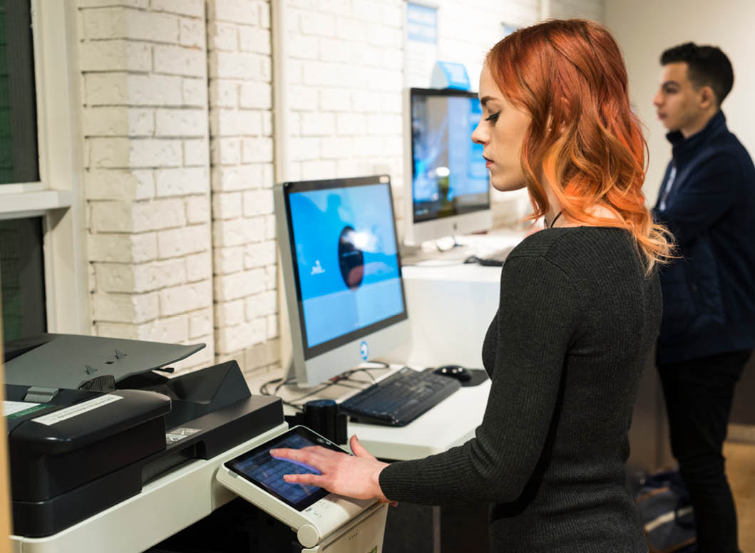 Photo of two students at the Printshop services on campus. 