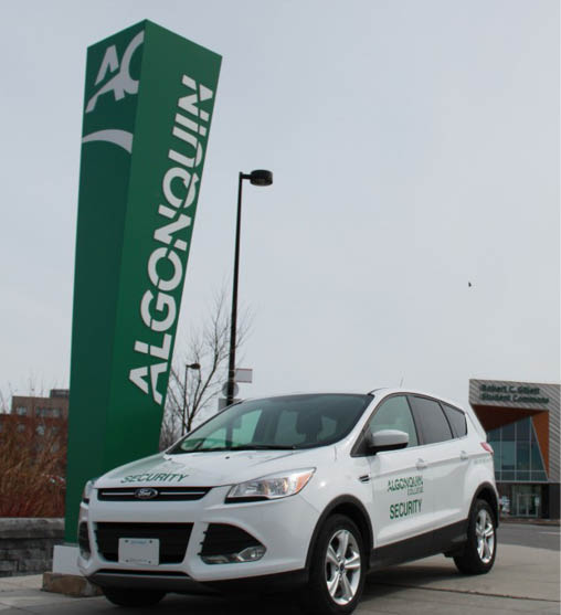 Photo of a College Safety Car at the entrance sign at the Ottawa Campus.