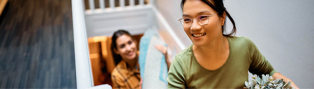 Smiling professional helping a student at a laptop.