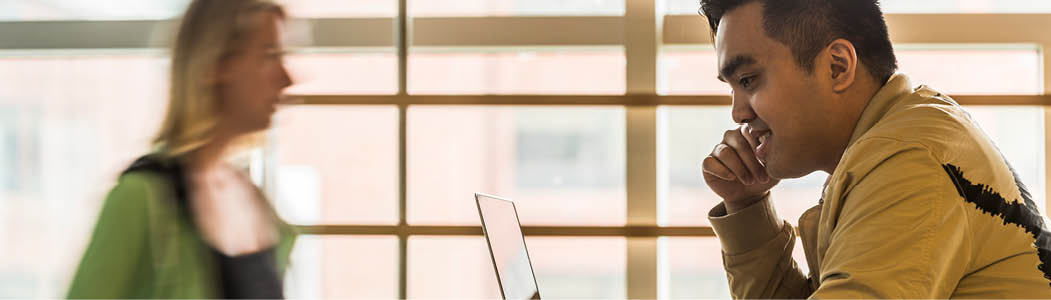 Students working while others walk by at the Ottawa campus.