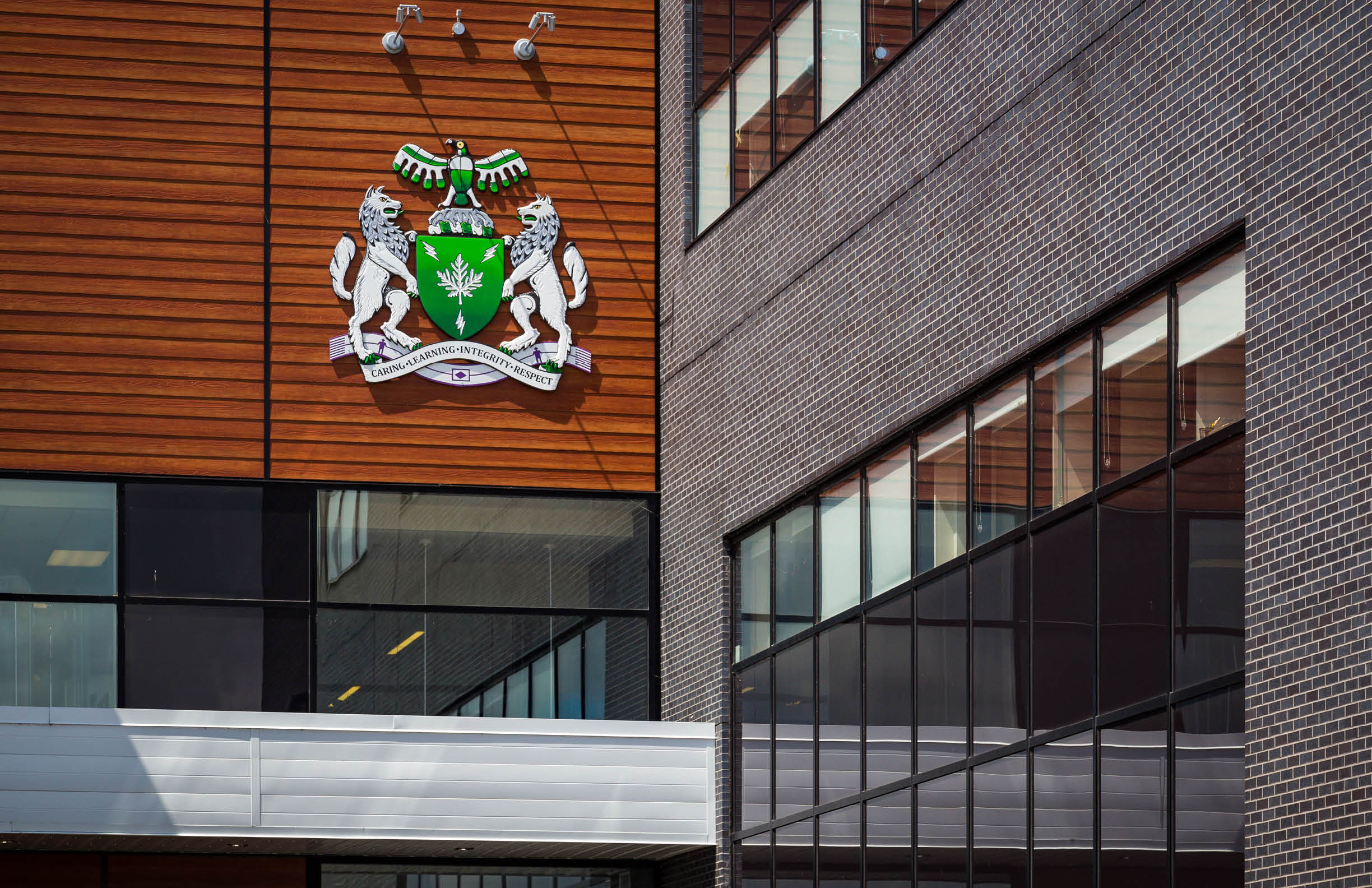 Close-up of the Algonquin Crest on the outside of the Pembroke Campus building.