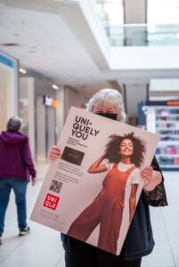 A student holding up an example of their campaign artwork
