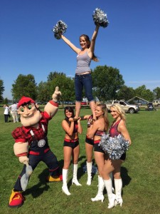 A group of Ottawa RedBlacks cheerleaders lift a student in the air