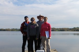 A group of Environmental Technician students on a sunny fall day, standing in front of a lake