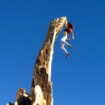 Outdoor Adventure graduate Leslie Timms - expert rock climber hanging from tall rock - Graduate Success Stories