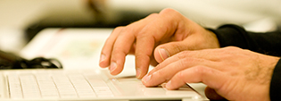 Male hands typing on a laptop