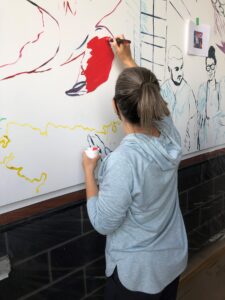Students and staff painting mural