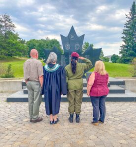 Marcie Lane's daughter, cadet Olivia Vernelli, salutes at the Fallen Soldier Memorial at Garrison Petawawa, while Marcie and her parents look at the memorial