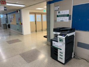 Image of a Konica Minolta colour printer on the second floor of A building in the hallway across from room A214.