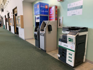 Image of a Konica Minolta colour printer on the first floor of E building located in the hallway beside room E120 and across the hall from Starbucks.
