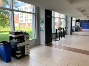 Image of a Konica Minolta colour printer on the first floor of Residence located in the main lobby near the doorway to the courtyard.